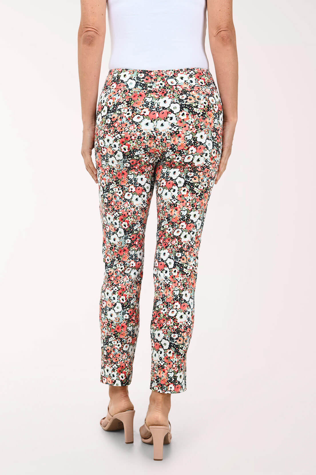 Floral patterned pants worn by a person on a white background