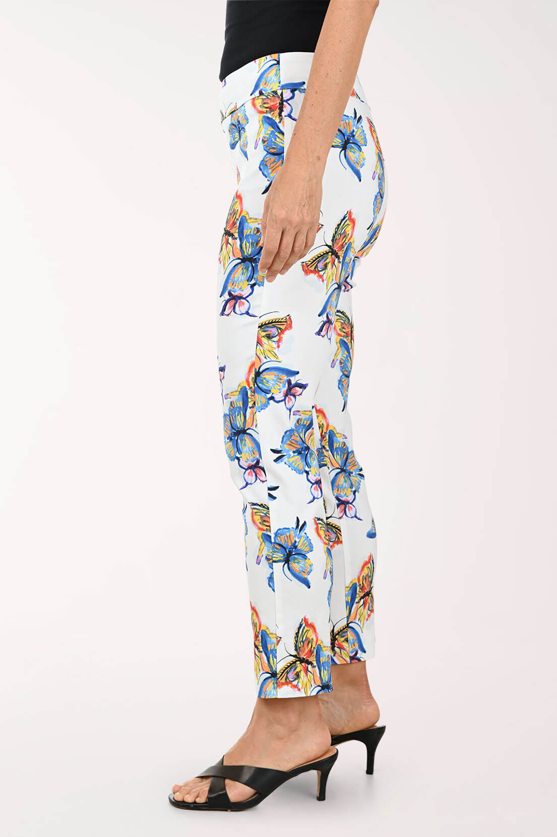Colorful butterfly-patterned pants worn by a person on a white background