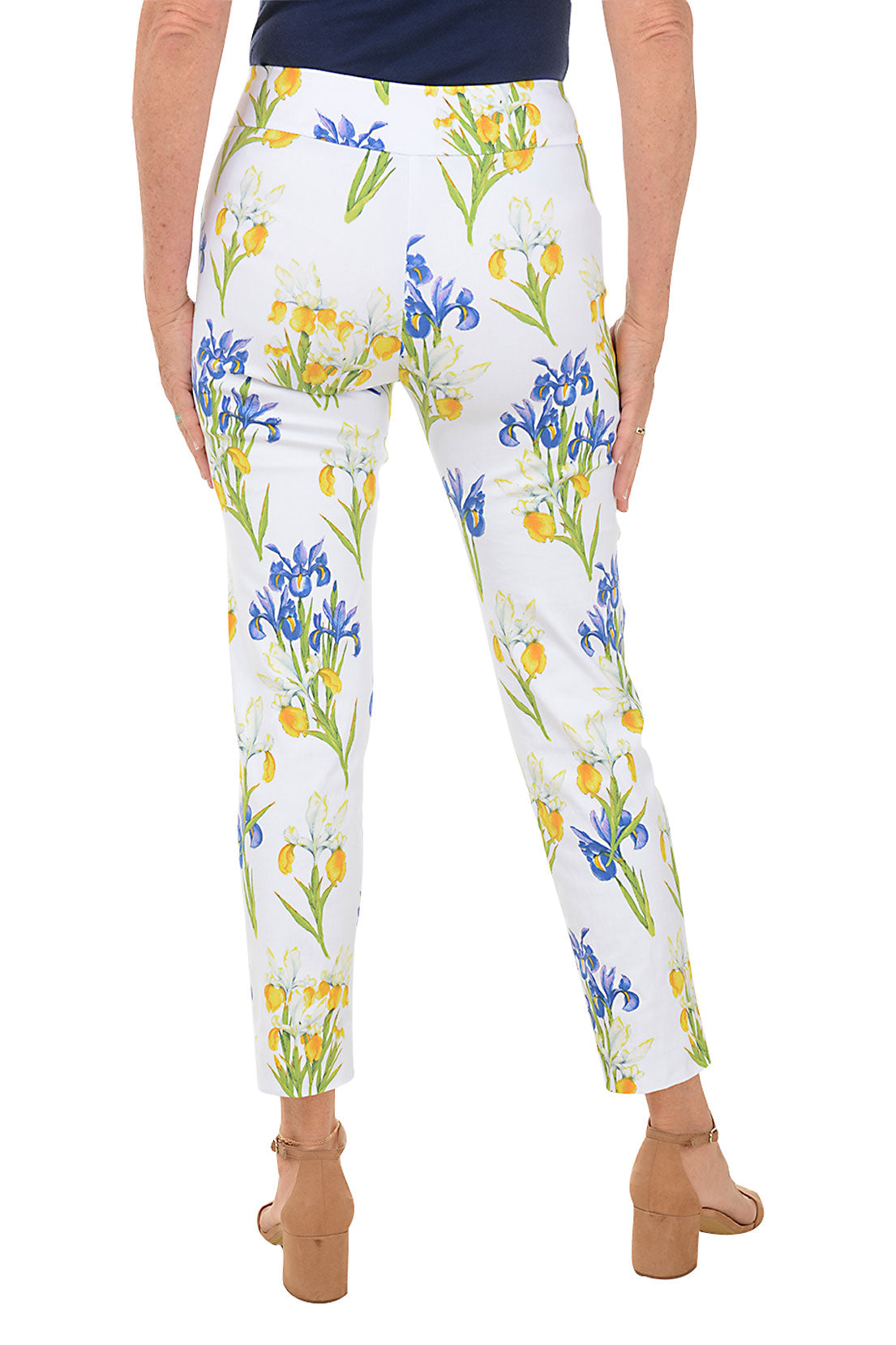 A back shot of a model wearing a pair of pull-on ankle pants with an elasticized waistband, featuring a white base with a blue and yellow floral pattern.