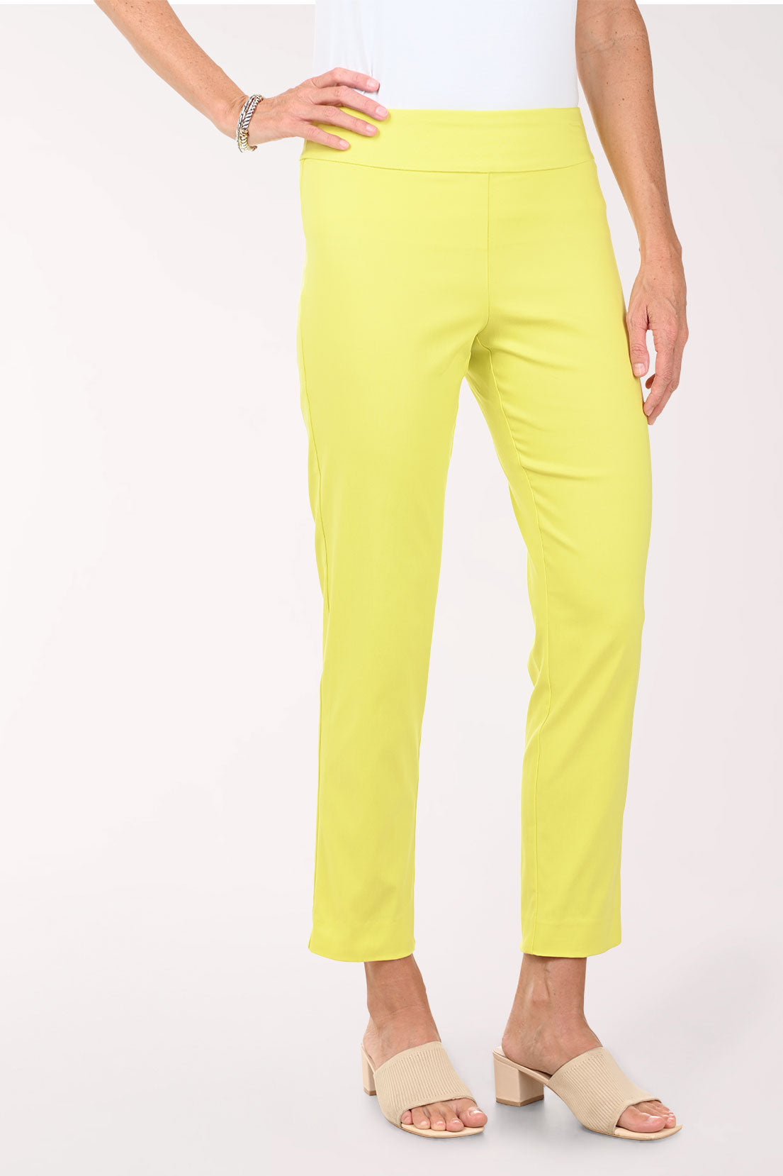 Person wearing bright yellow pants on a white background