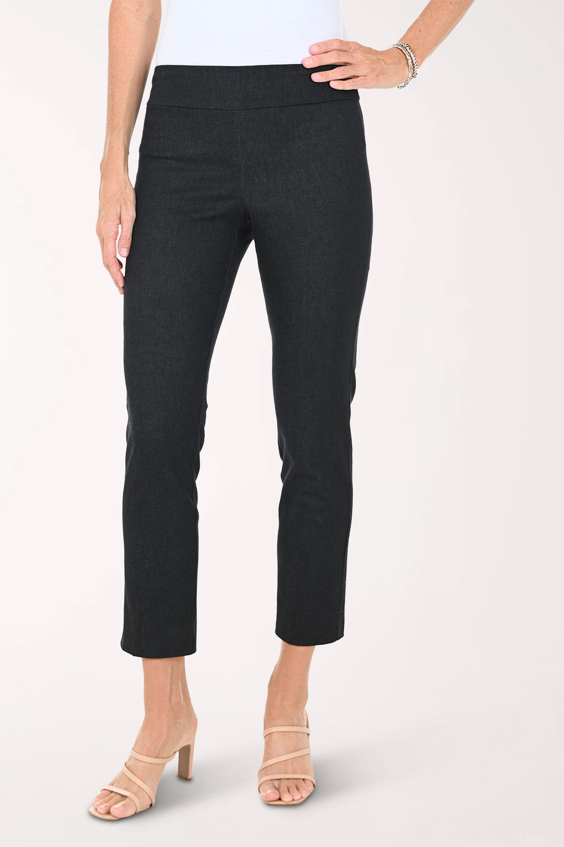 Slim black pants worn by a person on a white background
