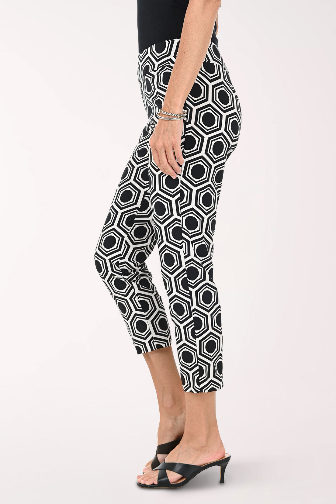 Person wearing black and white geometric patterned pants on a white background