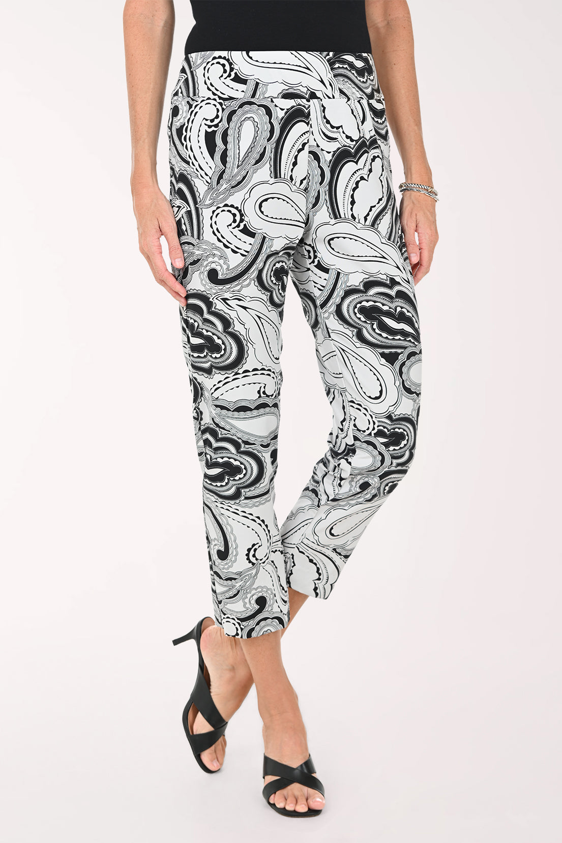 Person wearing black and white patterned pants on a white background