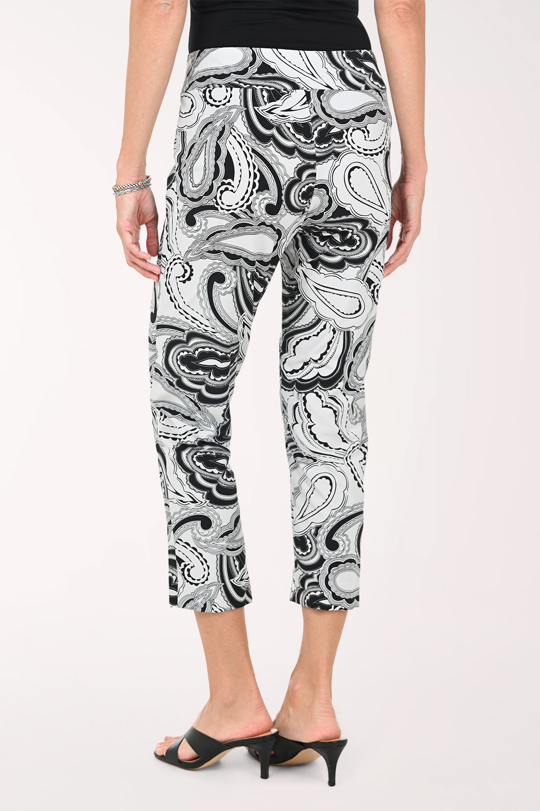 Person wearing black and white patterned pants on a white background