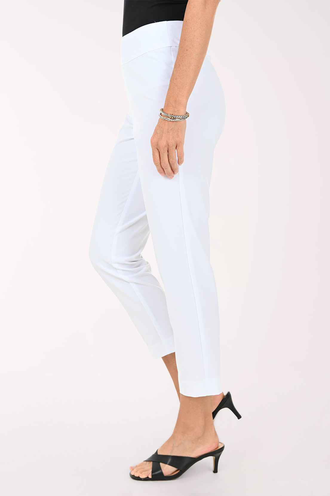 Person wearing white ankle pants on a white background