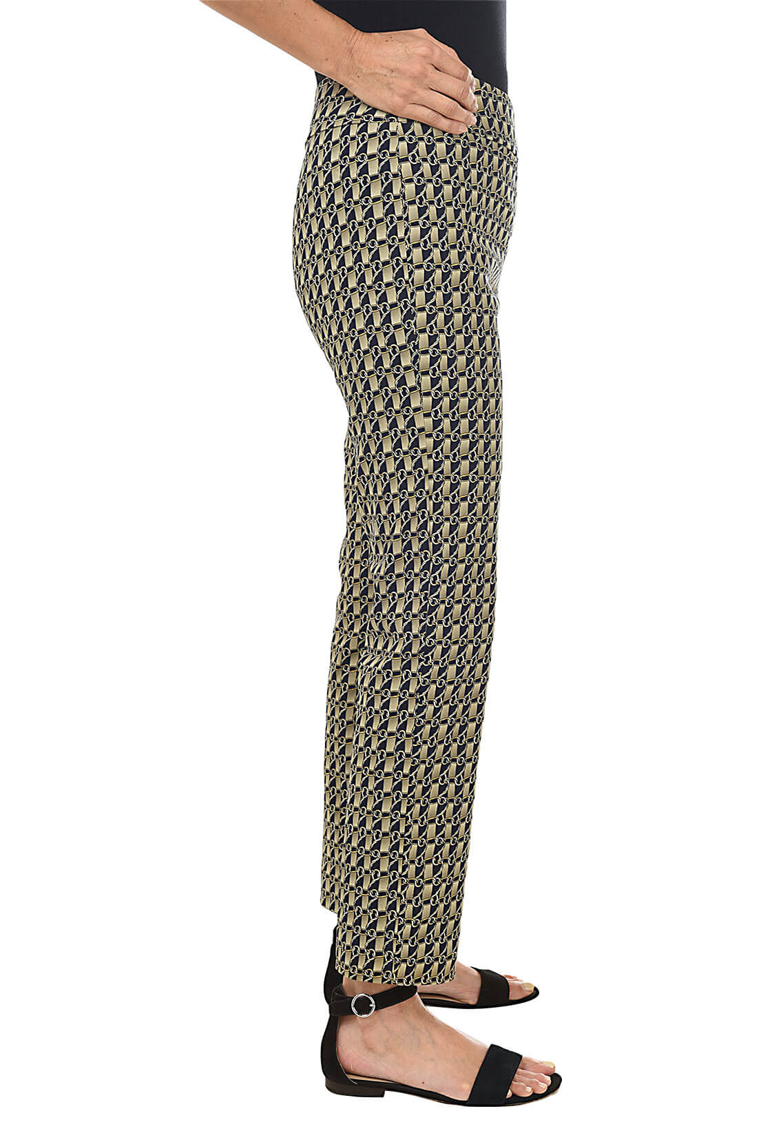 A side shot of a model wearing a pair of slim-fit golden link print pull-on ankle pants with an elasticized waistband, made from a blend of nylon, rayon, and spandex fabrics.