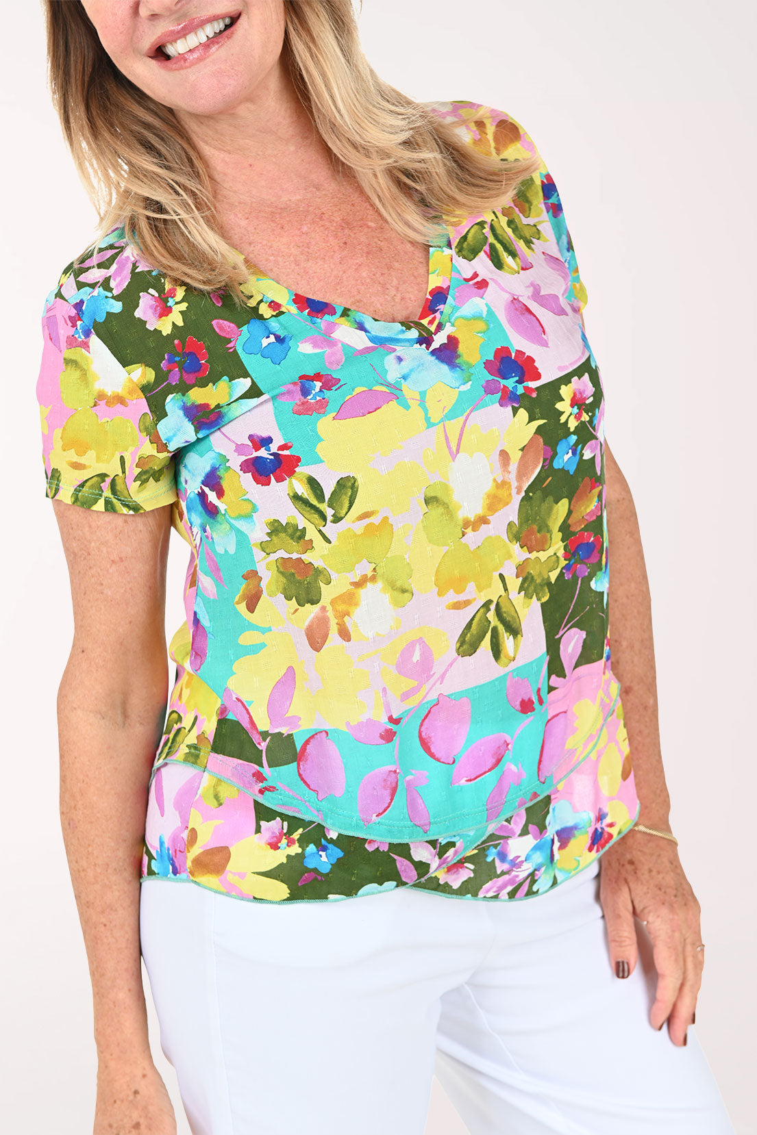 Woman wearing a multicolored orchid print short sleeve top