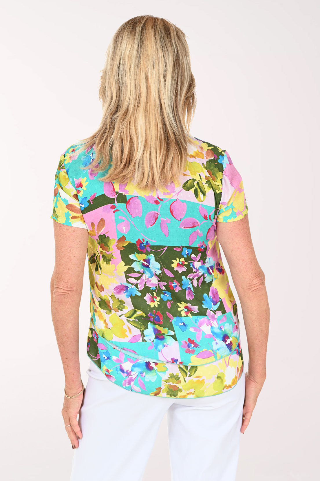 Woman wearing a multicolored orchid print short sleeve top