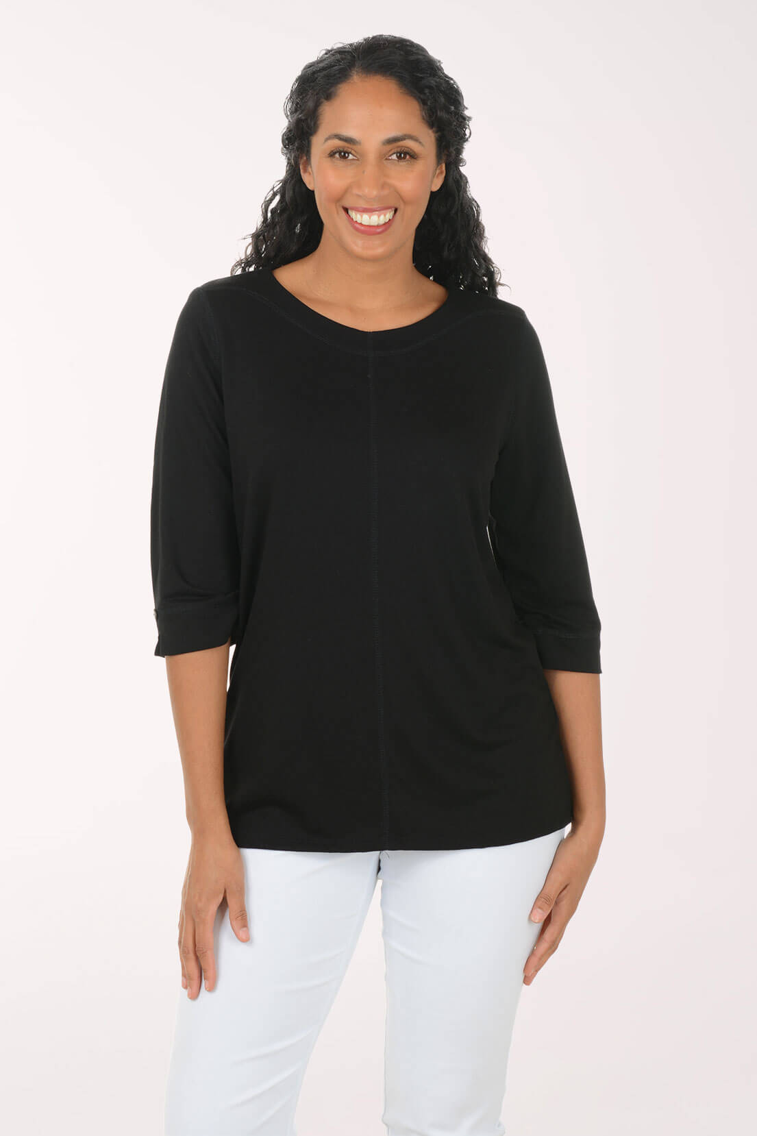 Woman wearing a black top and white pants on a white background