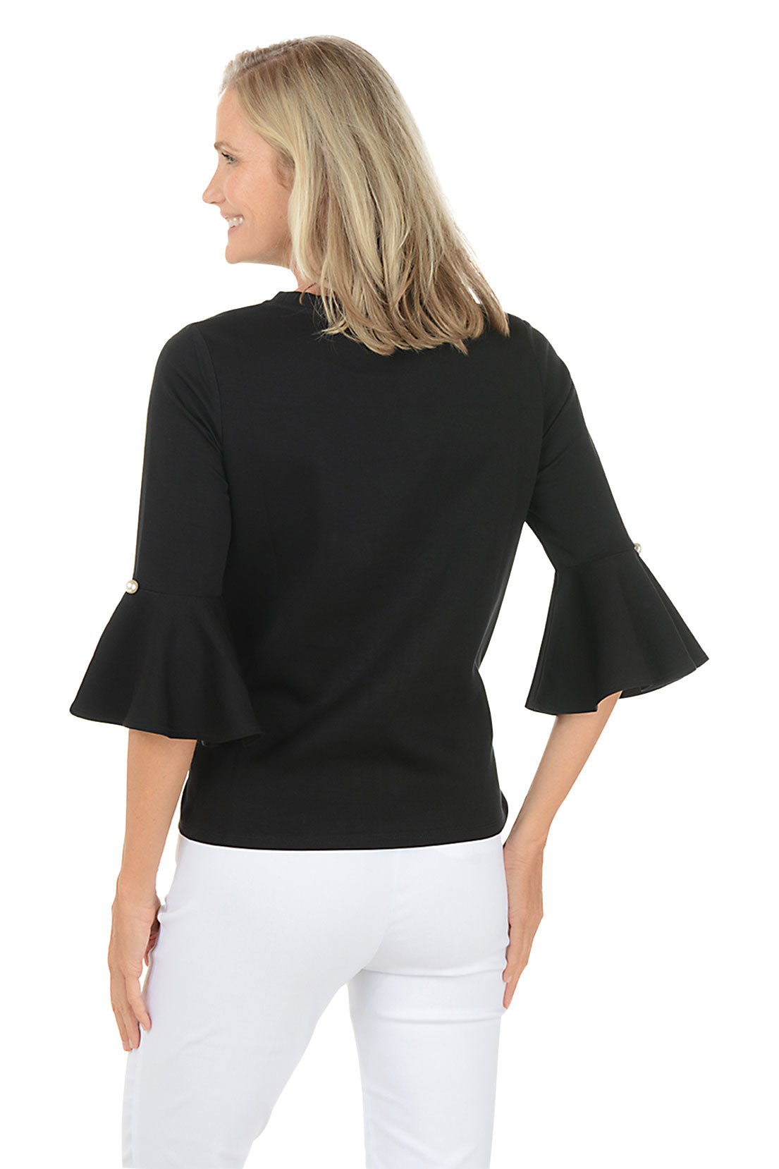 Woman wearing a black bell-sleeve top and white pants on a white background. Back shot.