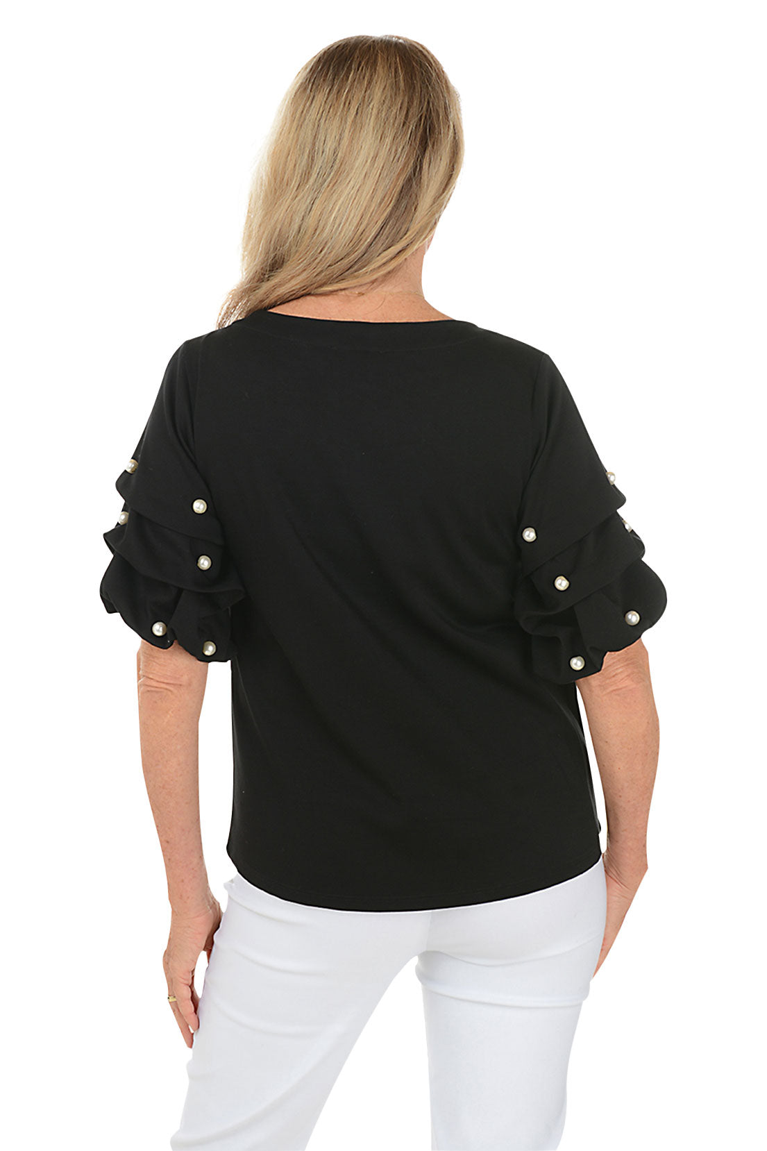 A back shot of a model wearing a black top with a scoop neck and pearl gathered elbow sleeves with embellishments. She is also wearing white pants.