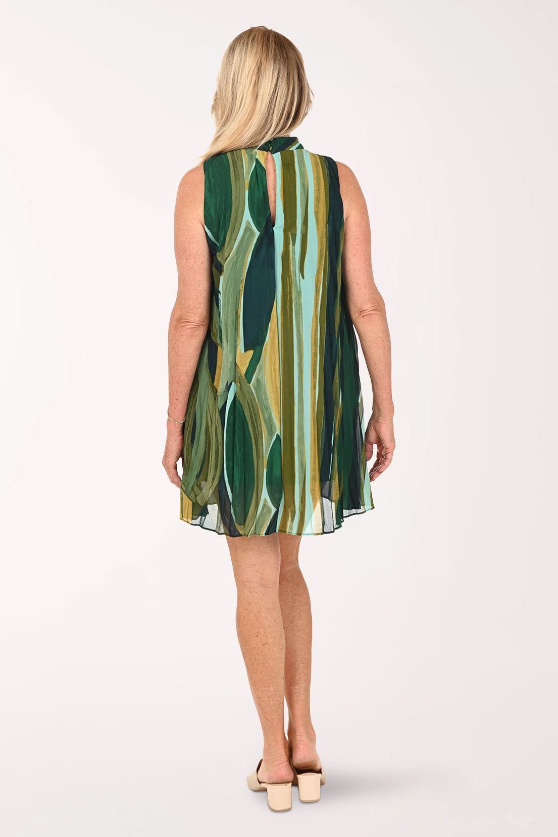 Woman wearing a sleeveless green abstract dress