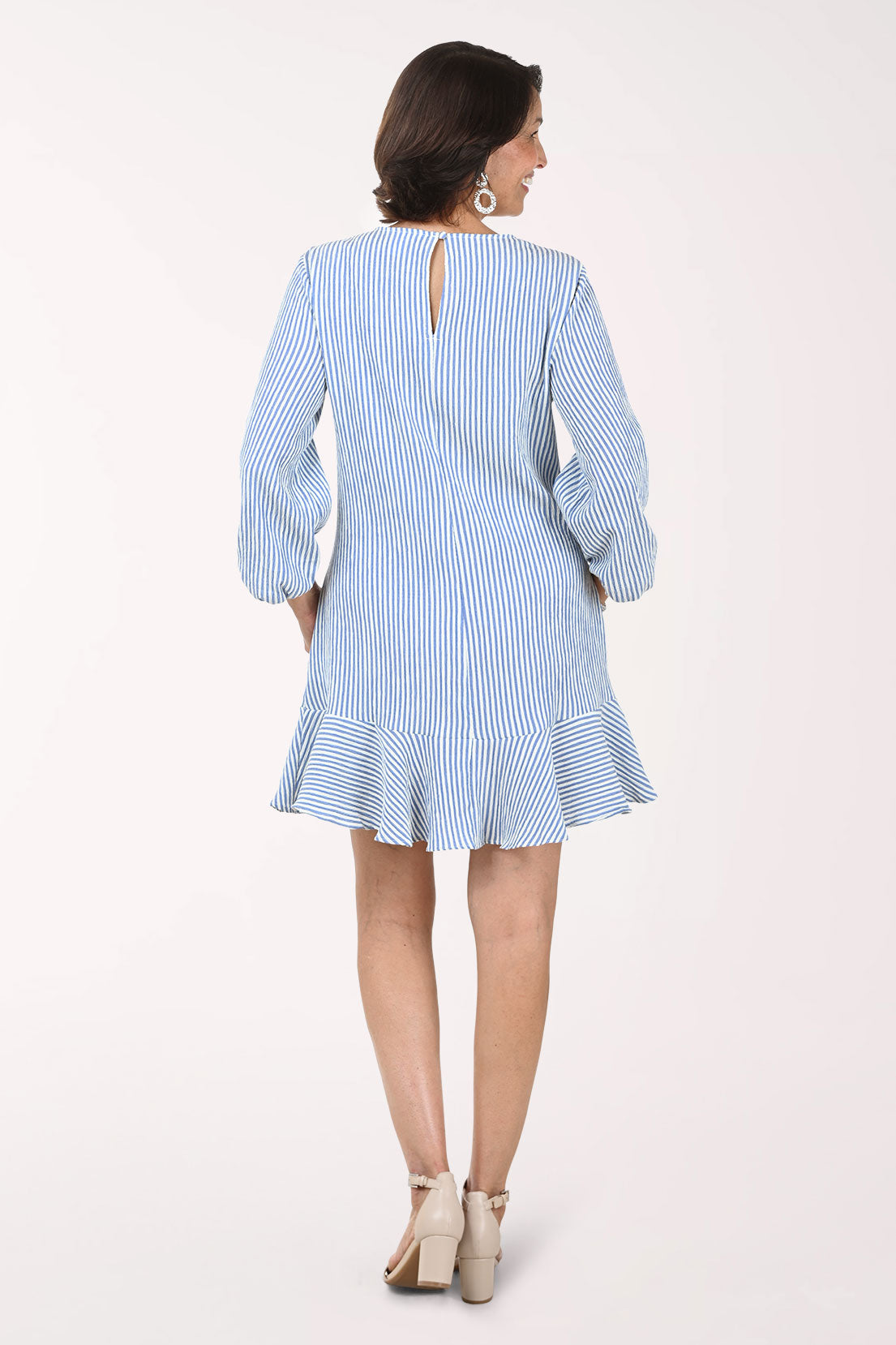 Woman wearing a light blue and white striped dress on a white background