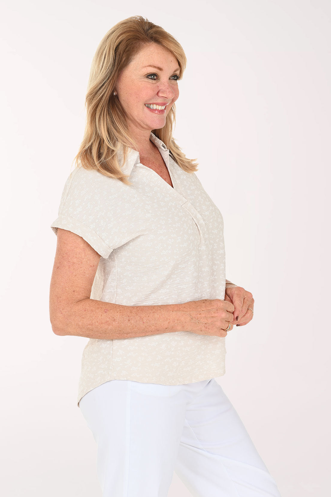 Woman wearing a beige short sleeve collared blouse