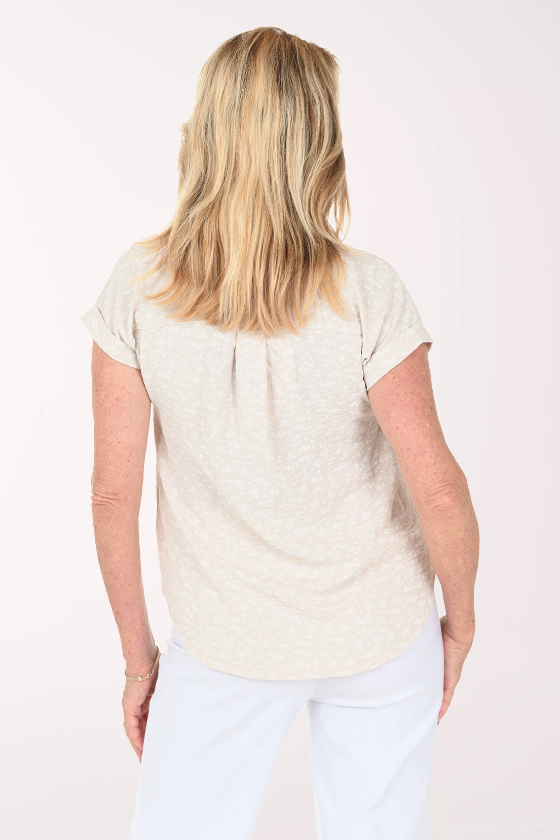 Woman wearing a beige short sleeve collared blouse