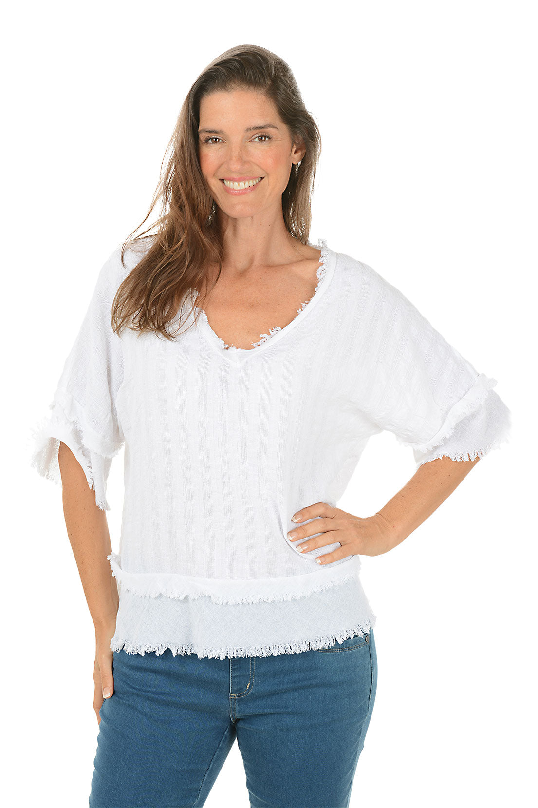 Woman wearing a white blouse with frayed edges and blue jeans on a white background