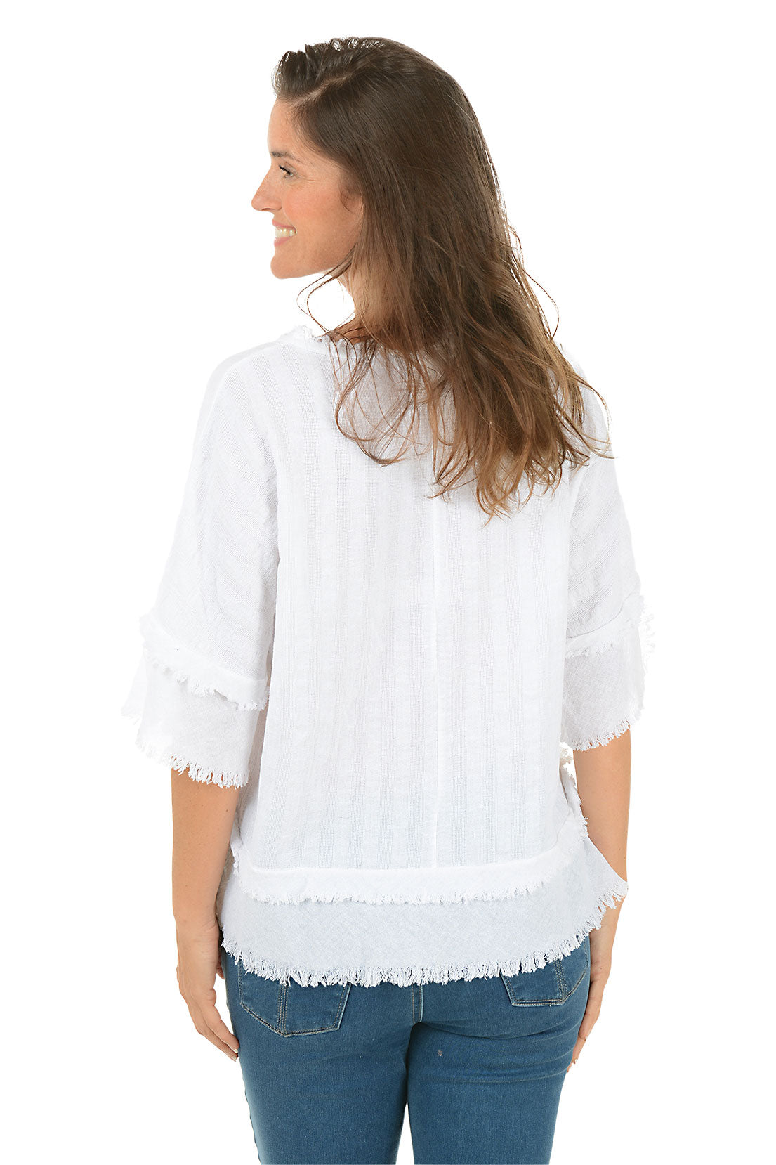 Woman wearing a white blouse with ruffled details on a white background. Back shot.