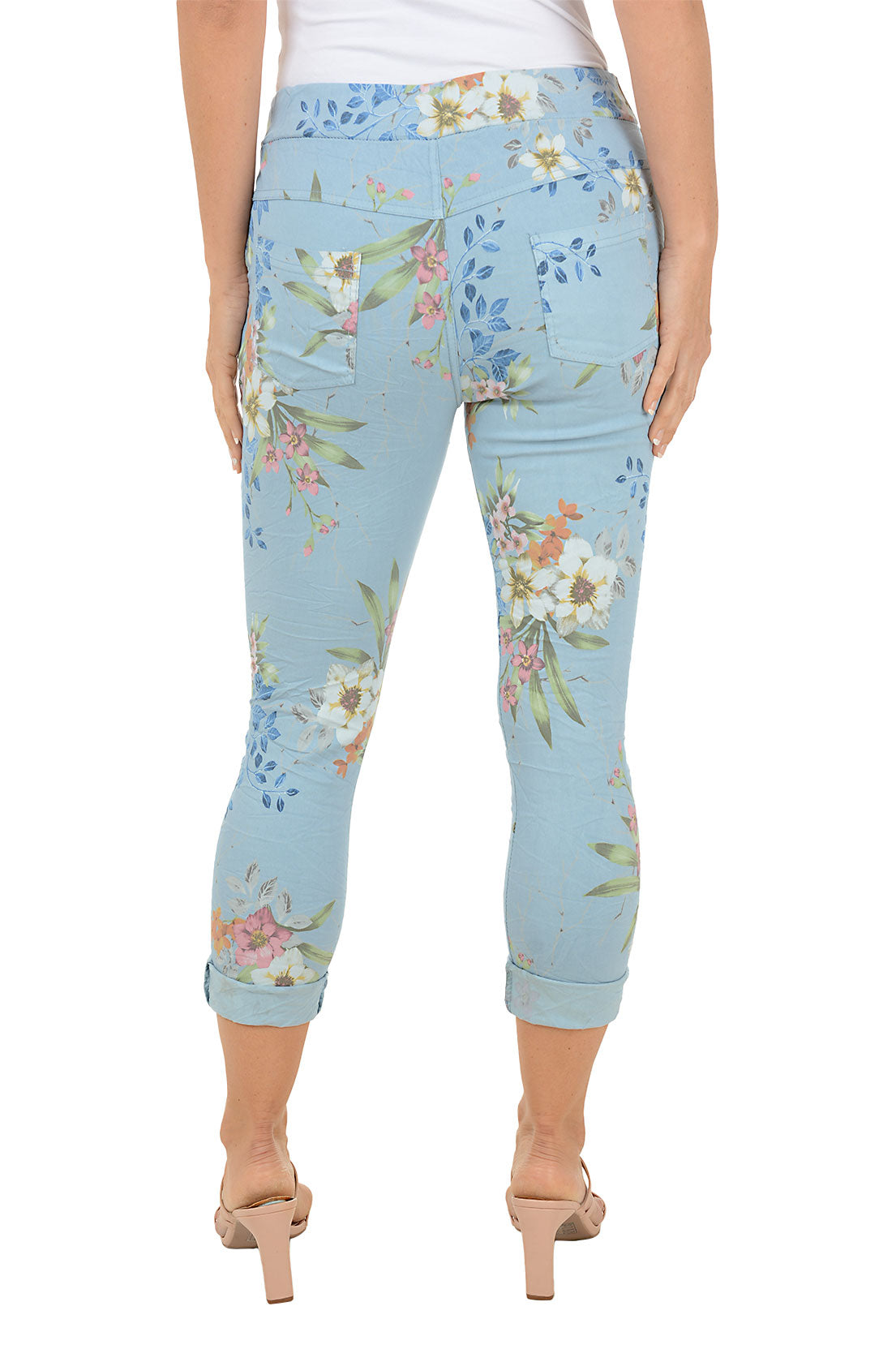 Light blue capri pants with floral pattern worn by a person on a white background. Back shot.
