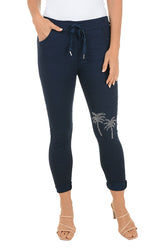 Navy blue pants with palm tree design on a white background.
