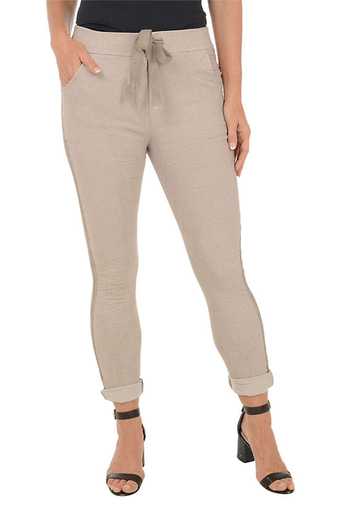 Beige pants with a stripe on the side worn by a person on a white background.