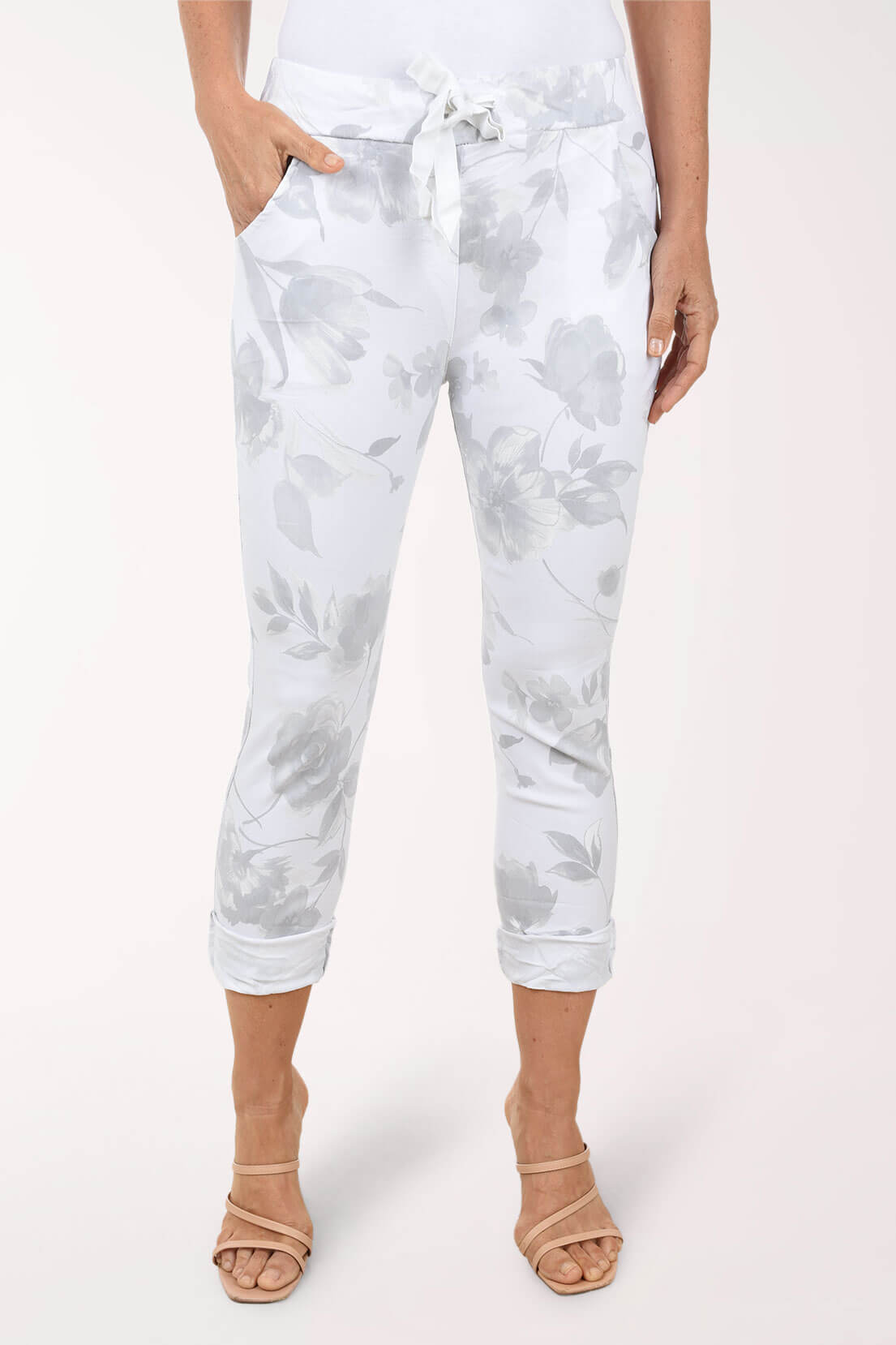 Person wearing white tie-dye pants on a light pink background