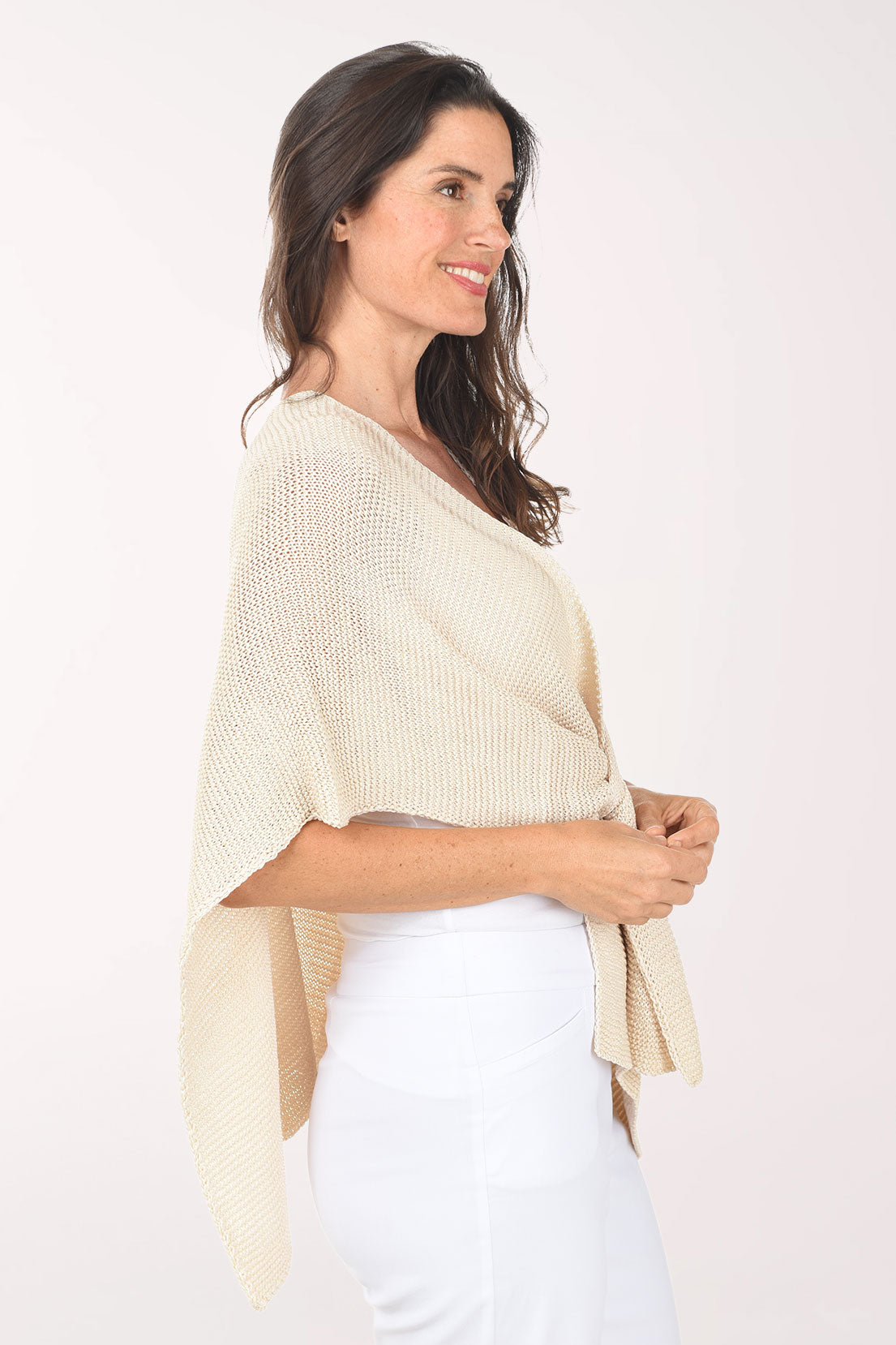 Woman wearing a beige knitted shawl on a white background