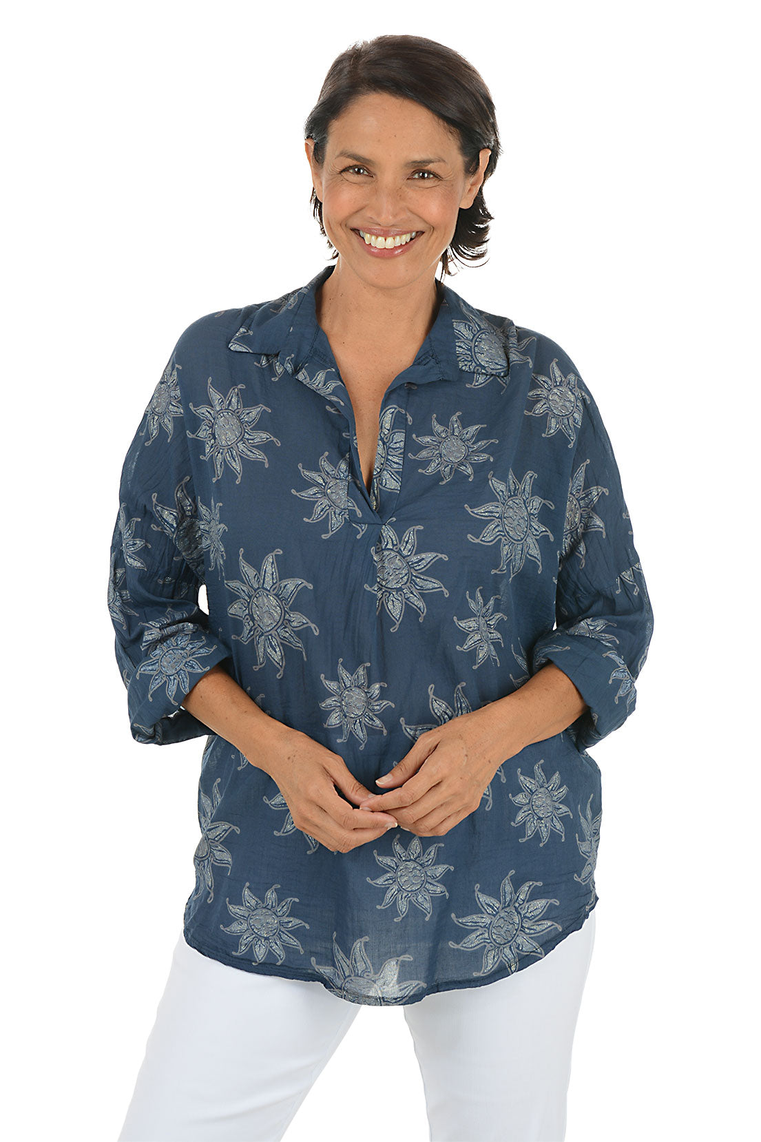 Woman wearing a blue floral patterned shirt on a white background.