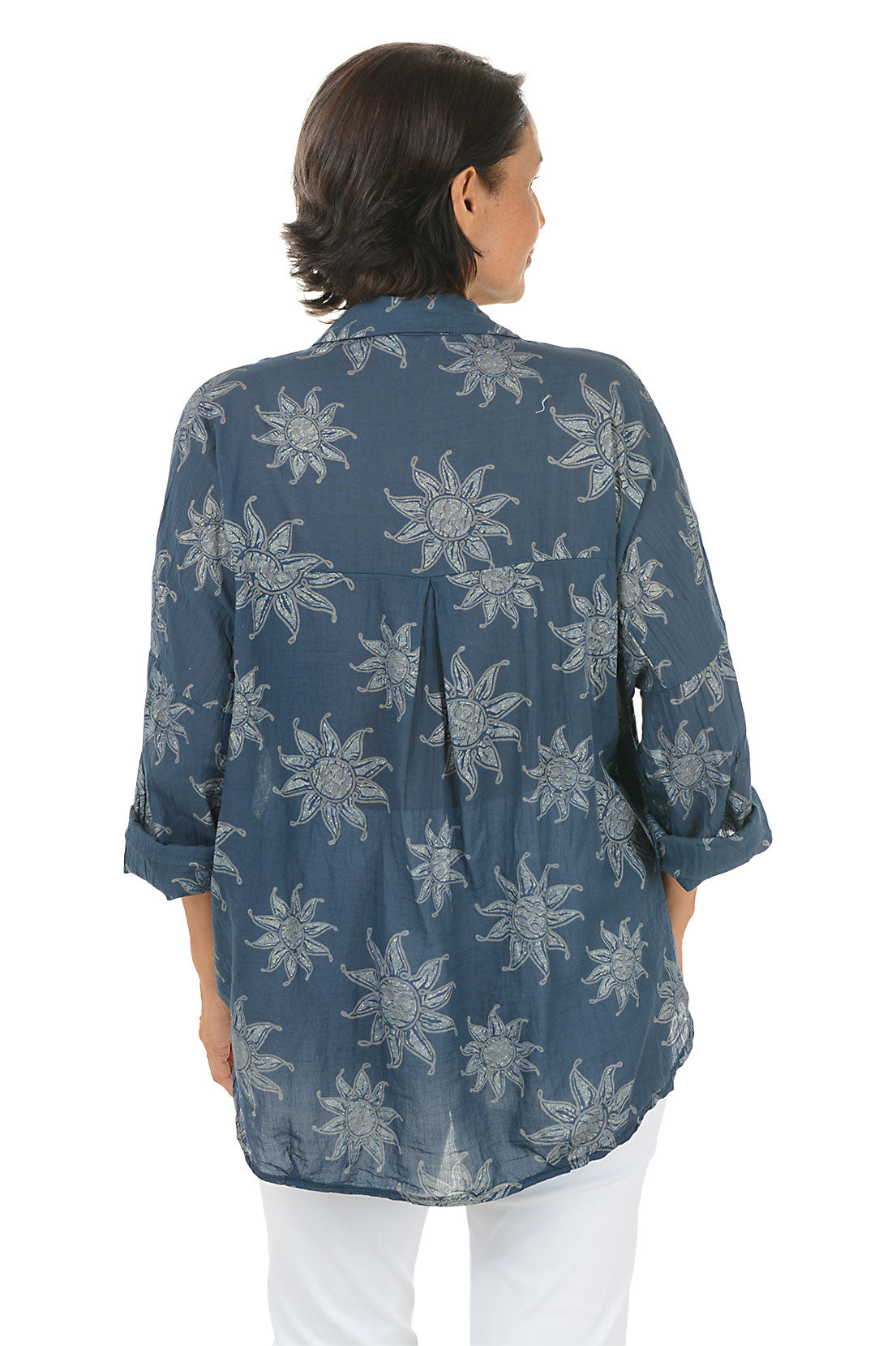 Woman wearing a blue floral patterned shirt on a white background. Back shot.