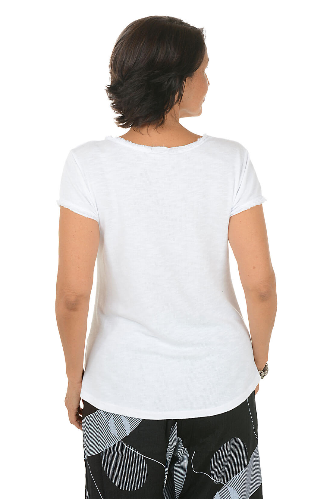 Woman wearing a white t-shirt and black patterned pants on a white background