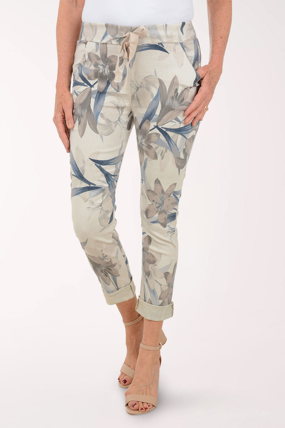 Woman wearing beige joggers with multicolored flowers.