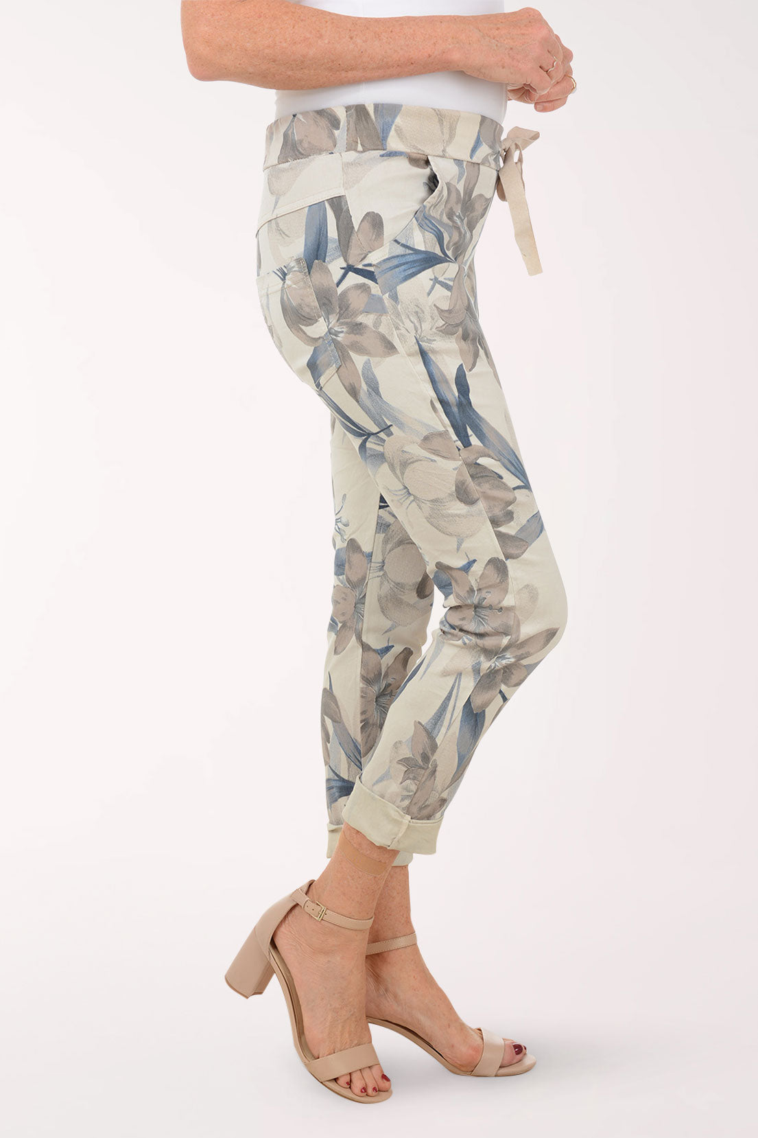 Woman wearing beige joggers with multicolored flowers.