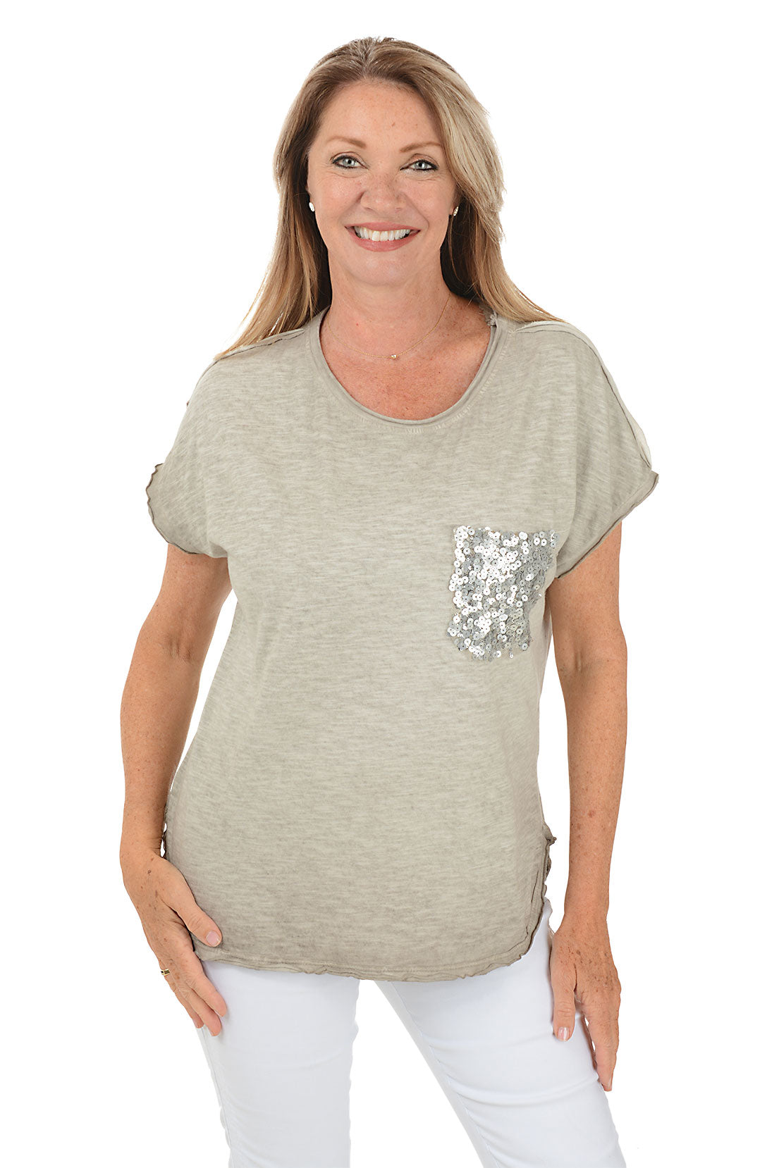 A front shot of a model wearing a beige scoop neck tee with short dolman sleeves and a sequined left chest pocket, paired with white pants.