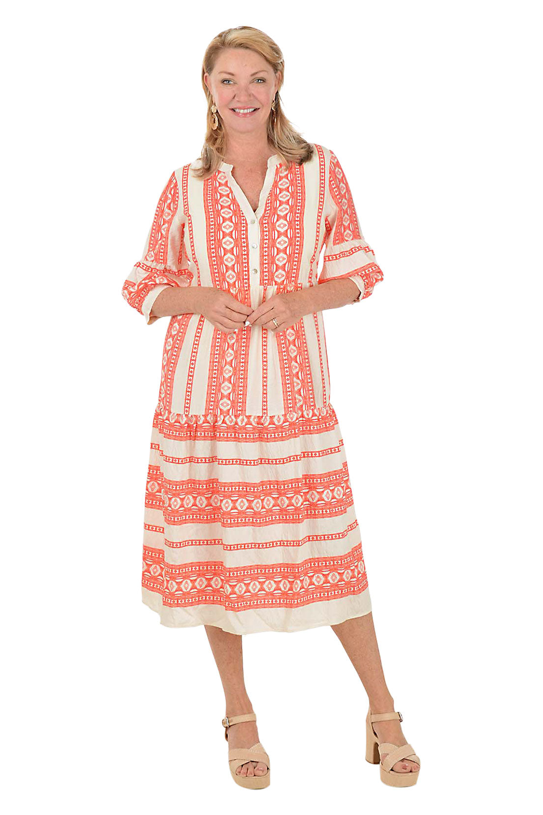 Woman wearing a coral and white patterned midi dress on a white background. Second front shot.
