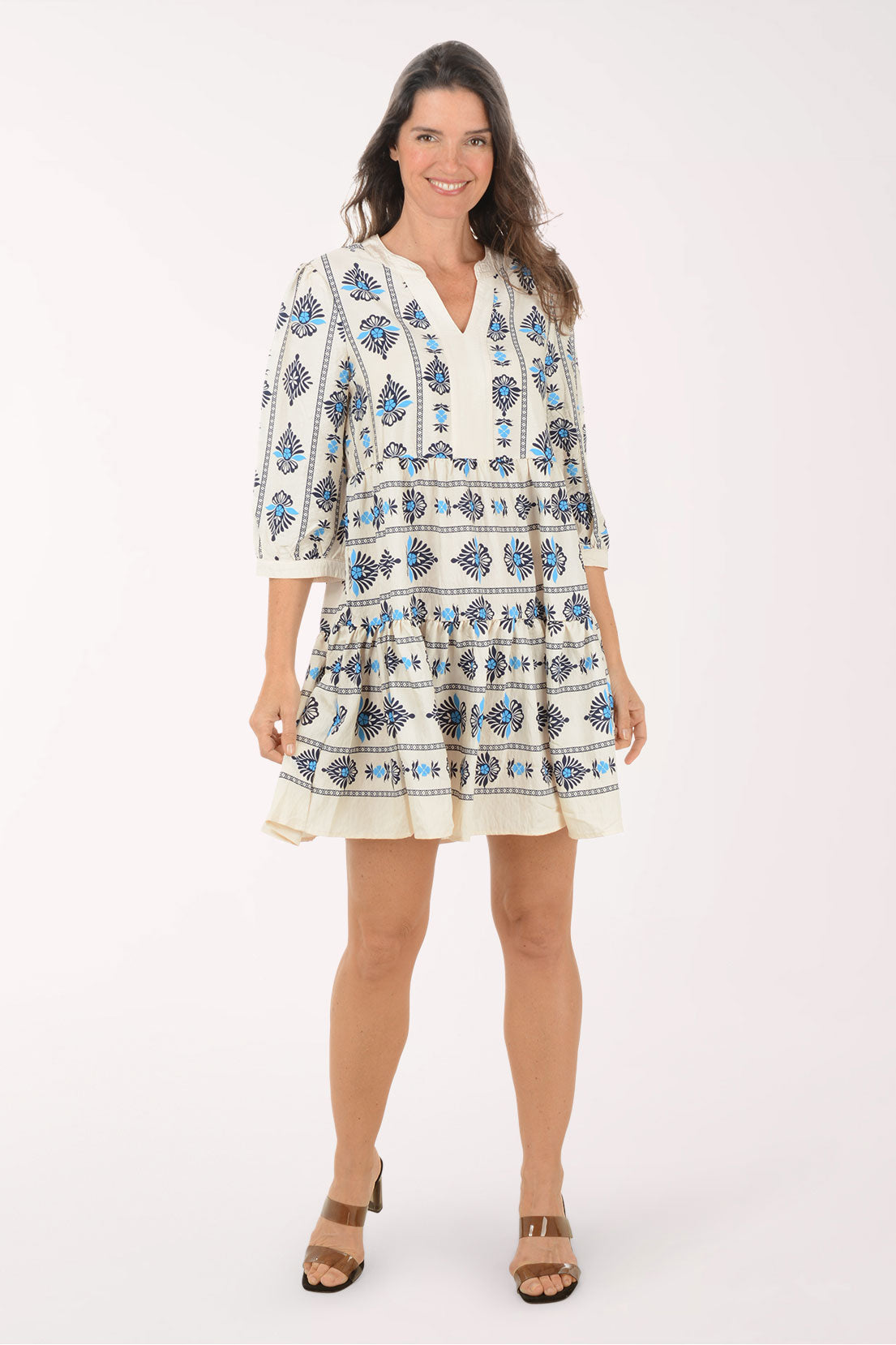 Woman wearing a white dress with blue floral patterns on a white background