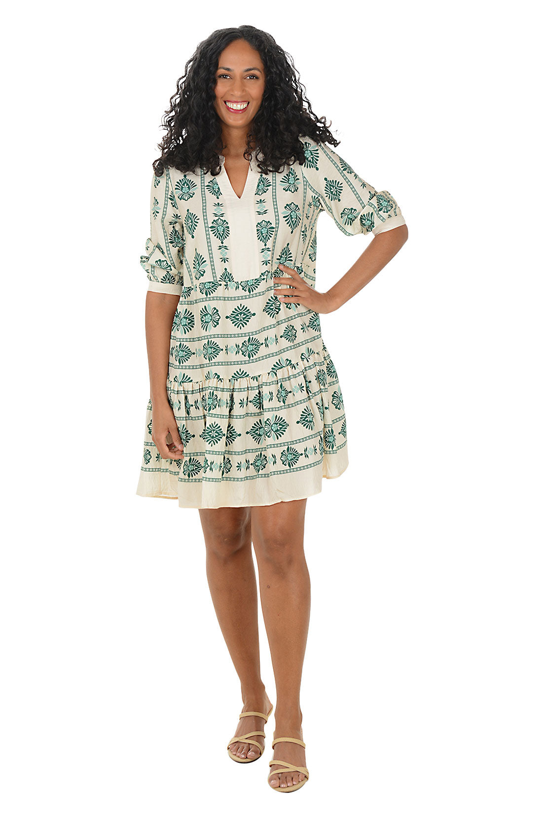 Woman wearing a 3/4 sleeve green and white patterned dress on a white background. Second front shot.