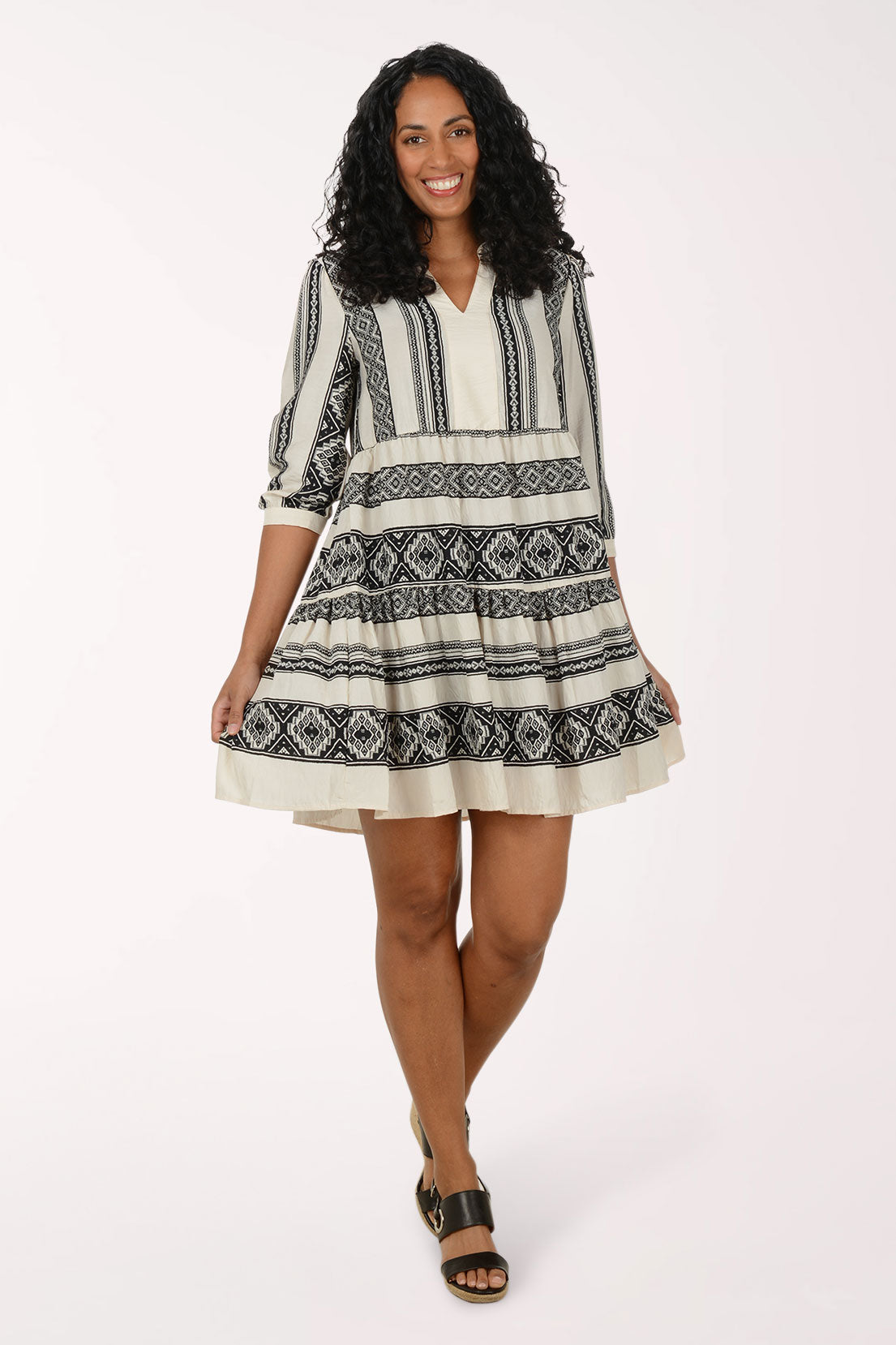 Woman wearing a black and white patterned dress on a white background