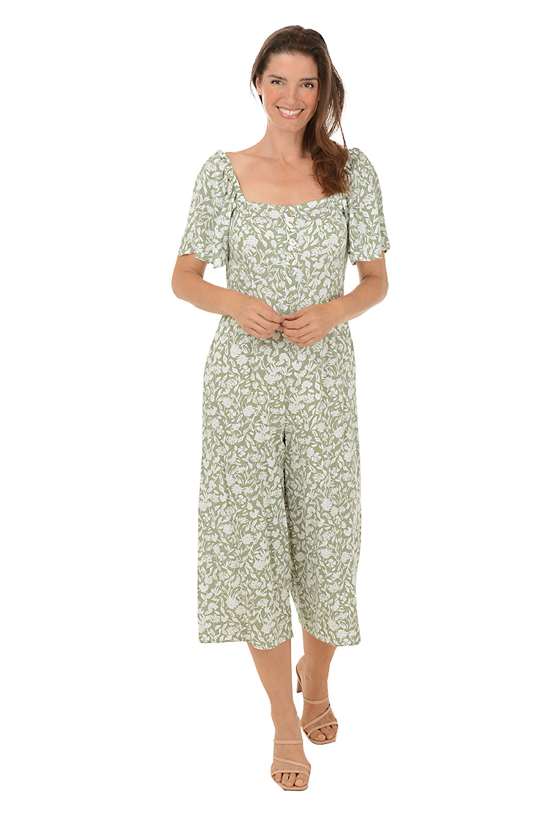 A front shot of a model wearing an olive floral square neck jumpsuit with short flutter sleeves and wide legs.