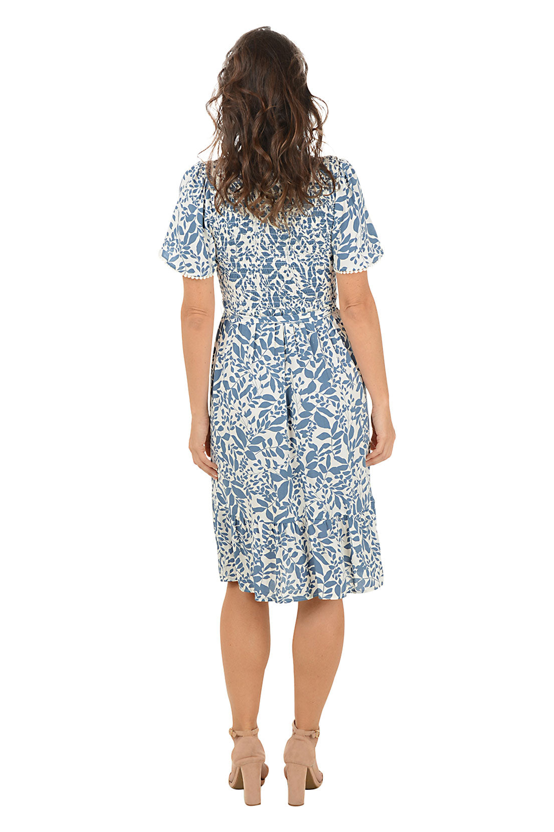 Woman wearing a blue floral dress on a white background. Back shot.