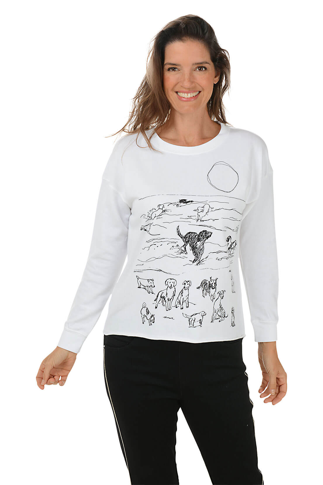 A woman wears a white sweatshirt with a dog print against a white background.