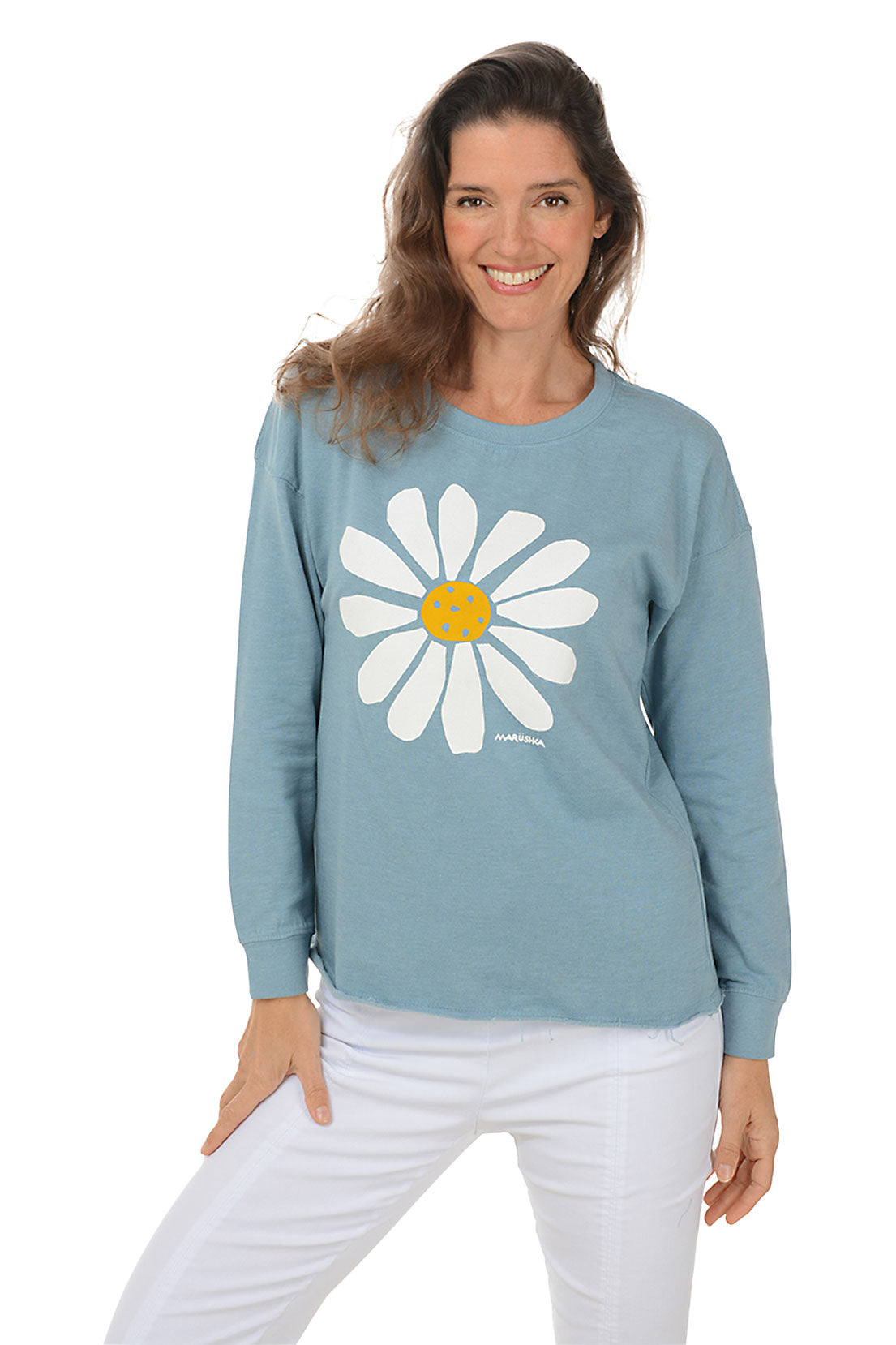 Woman wearing a blue sweatshirt with a white daisy design on a white background.