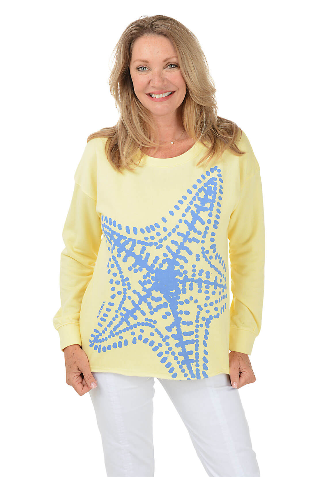 Woman wearing a yellow sweater with blue abstract pattern on a white background