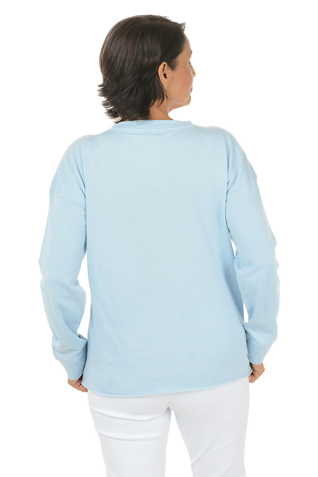 Woman wearing a light blue sweater and white pants on a white background