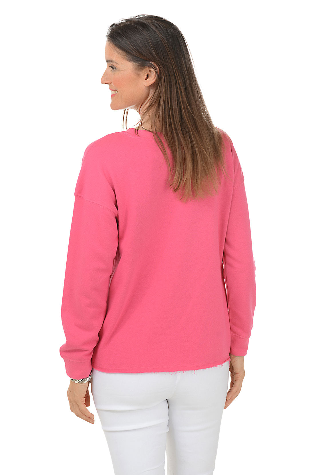 Woman wearing a pink long-sleeve sweater with a white daisy design on a white background. Back shot.