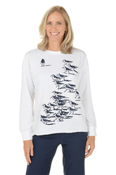 Woman wearing a white sweatshirt with black bird illustrations on a white background.