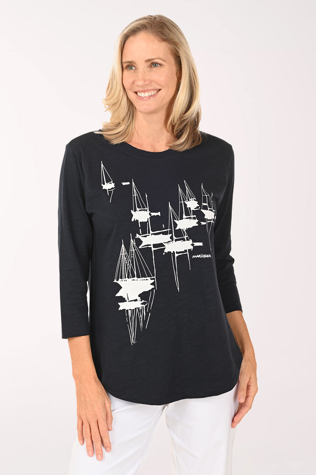 Woman wearing a navy and white top with sailboats
