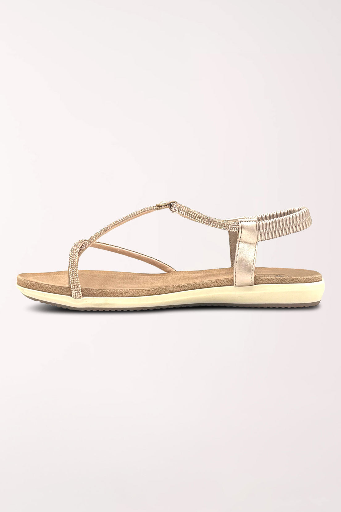 Inner side view of the champagne Viva sandal showing the rhinestone straps and flat cushioned sole.