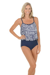 A woman wearing a blue and white one piece swimsuit with a blouson overlay.
