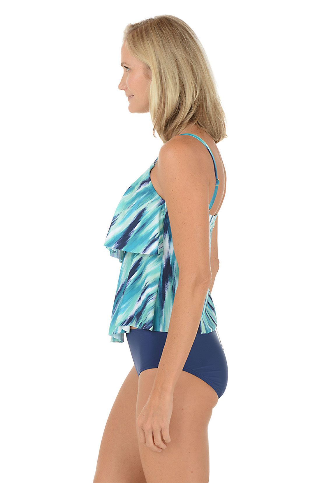 A woman wearing a blue tankini top with a double tiered detail. Side shot.