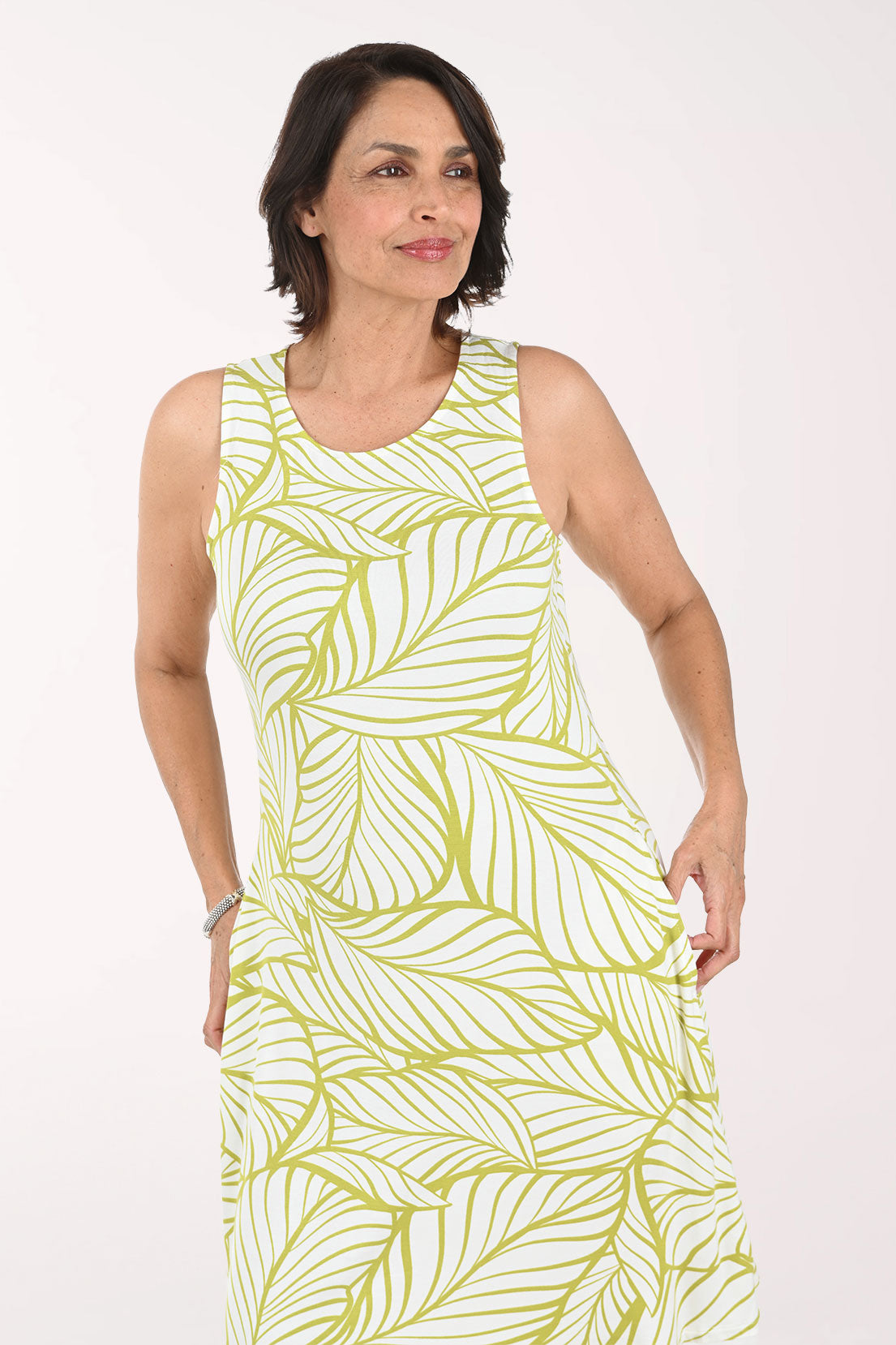 Woman wearing a sleeveless yellow dress with a palm print pattern