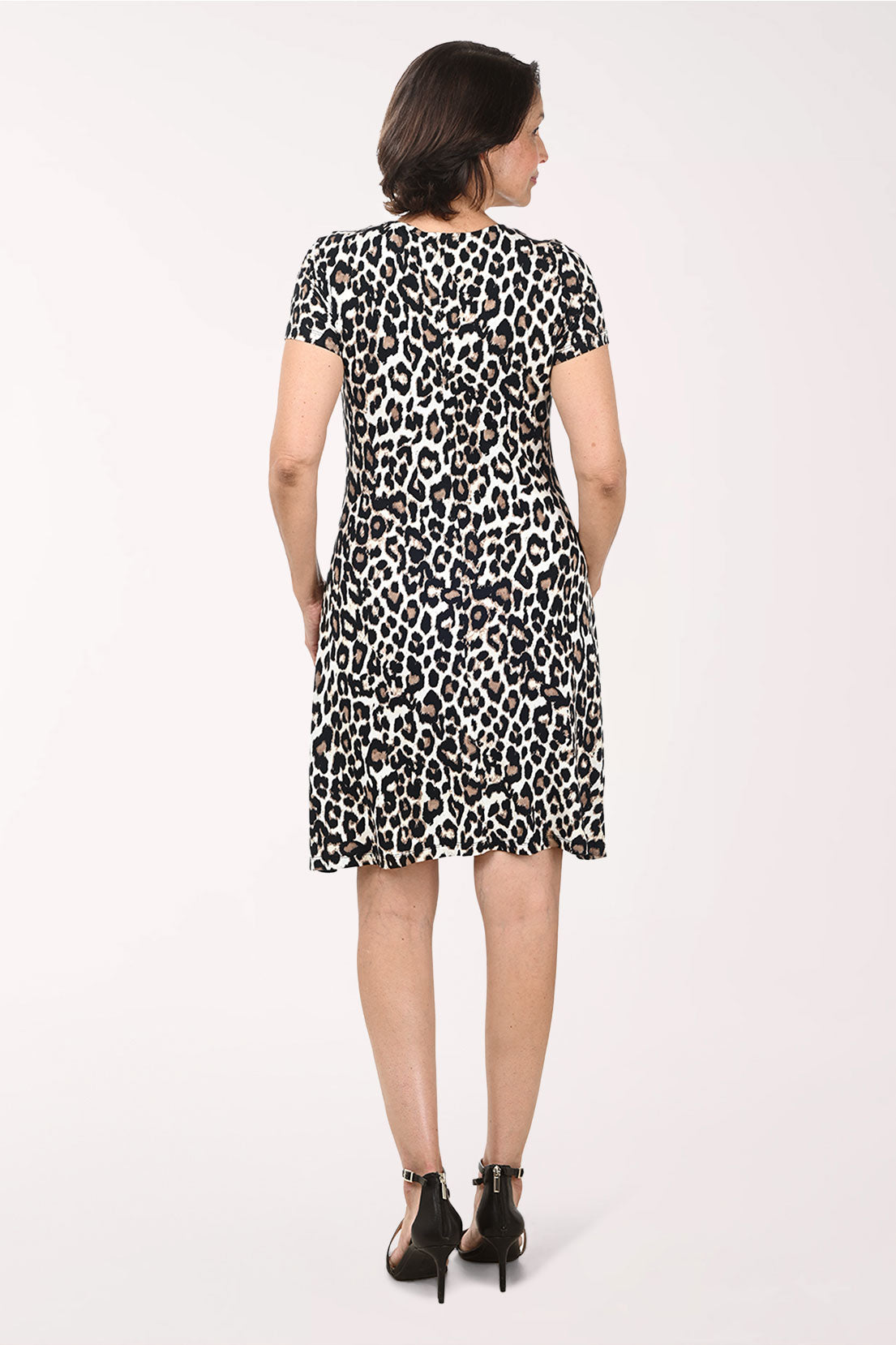 Woman wearing a leopard print dress on a white background